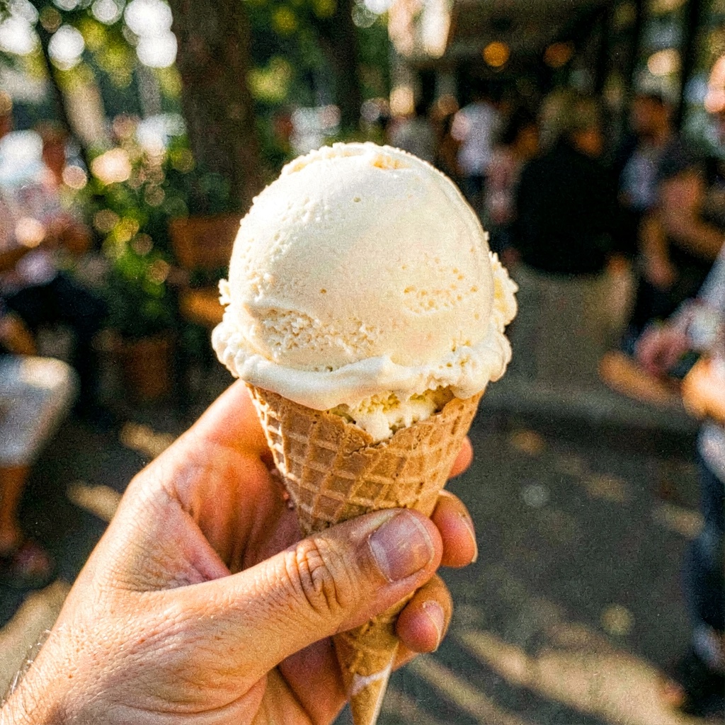 A hand holding a stretched scoop up to the camera